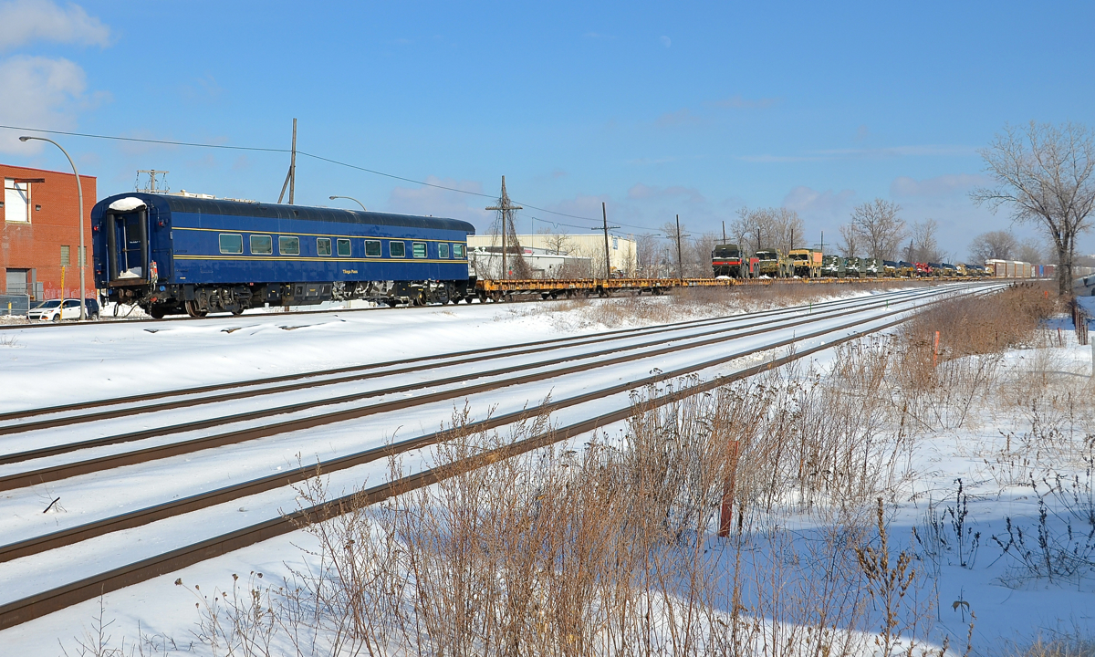 Bringing up the rear of a military move. CP 142 had a cut of militiary equipment at the rear today, with 15 flat cars holding military equipment, 3 empty flat cars and the private ex-CN car Tioga Pass at the very end.