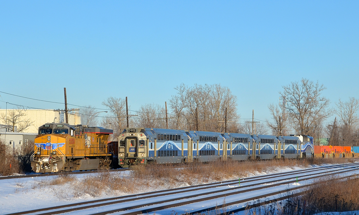 Union Pacific leading an AMT commuter train? No, not quite, but it kind of looks like that as AMT 19 with cab car AMT 3008 leading passes CP 143, stopped with UP 5550 leading. CP 143 will depart shortly and follow AMT 19 westwards along CP's Vaudreuil Sub.