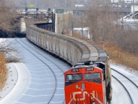 <b>Shoving on a long potash train.</b> Running for the first time, CN B730 has 153 potash loads from Yarbo, Saskatchewan destined for Saint John, New Brunswick as it leaves Turcot West after getting a new crew. ES44AC 2879 (with its marker light lit) is shoving on this long and heavy train.