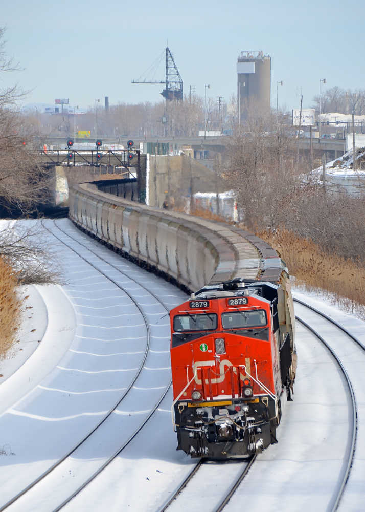 Shoving on a long potash train. Running for the first time, CN B730 has 153 potash loads from Yarbo, Saskatchewan destined for Saint John, New Brunswick as it leaves Turcot West after getting a new crew. ES44AC 2879 (with its marker light lit) is shoving on this long and heavy train.