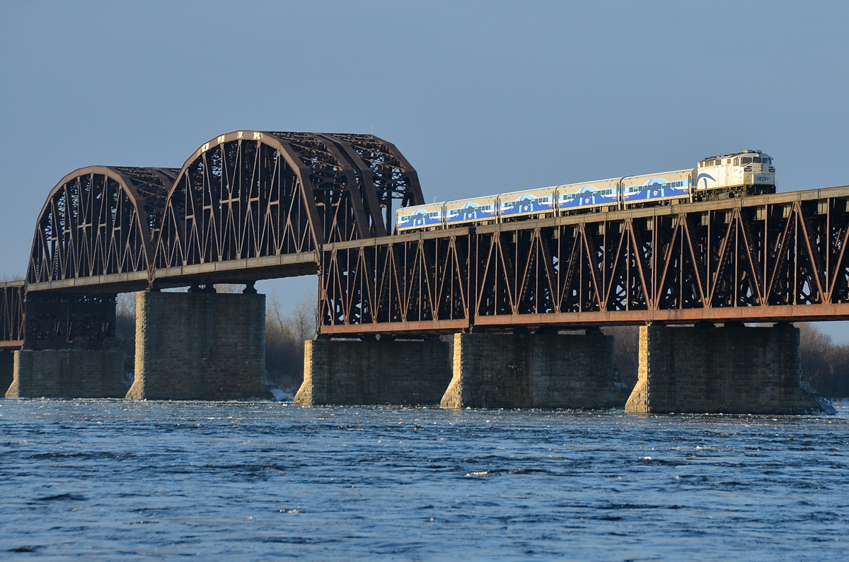 A matched AMT consist crossing the river. The stripes on the rear of F59PH AMT 1341 match the consist of 5 Comet cars which are trailing, all of which were repainted and refurbished a few years back. This is AMT 84, crossing the St-Lawrence river in the morning sun, just a couple of minutes from its first stop on the island of Montreal at Lasalle station.