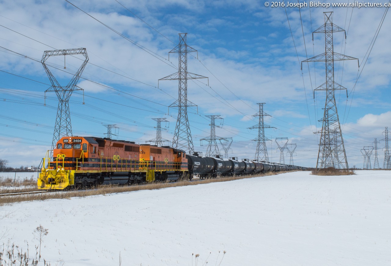 RLHH 595 slowly throttles up out of Garnet with RLHH 3404 and RLHH 3049.  They are approaching the Highway 3 road crossing during a brief period of sun on a mainly cloudy Tuesday.