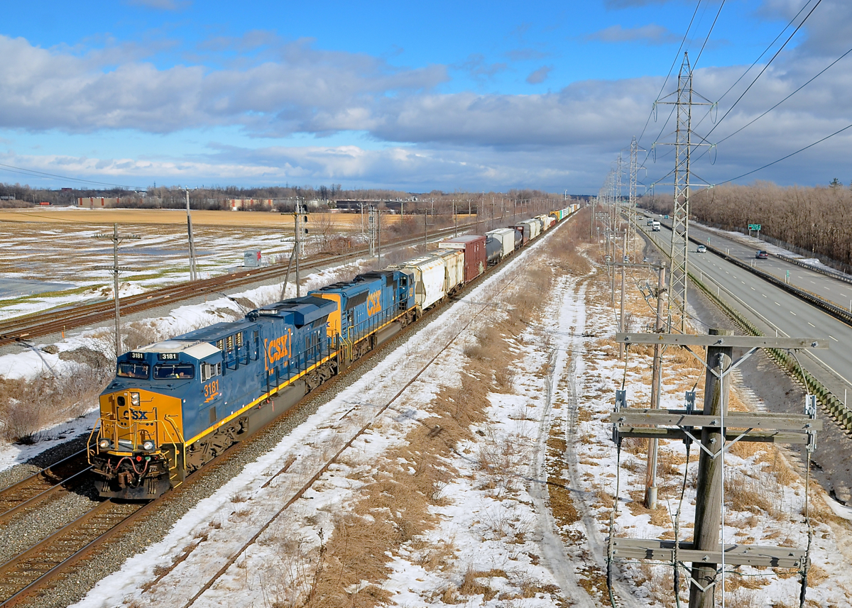 A fairly new ES44AH leading. A short CN 327 has just crossed over from the north to the south track of CN's Kingston sub in Sainte-Anne-de-Bellevue, at the western tip of the island of Montreal. Power is a fairly new ES44AH (CSXT 3181) & SD70MAC 4791.