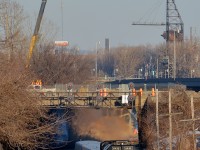 <b>A scene that will soon change.</b> As evidenced by the crane at the left in this photo, a lot of infrastructure work is going on in Montreal West near CN's Montreal sub. The short tunnel that VIA 67 is exiting will soon be demolished and I am unsure if the signal bridge will remain. Here VIA 67 led by VIA 6435 passes venerable signals with three LRC cars trailing.