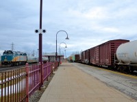 <b>Eastbound on both CN and CP.</b> Two eastbounds are through Dorval simultaneously, with VIA 50 at left on the Kingston sub seconds away from making its stop at VIA's Dorval station, while CP 118 at right passes through the AMT Dorval station.