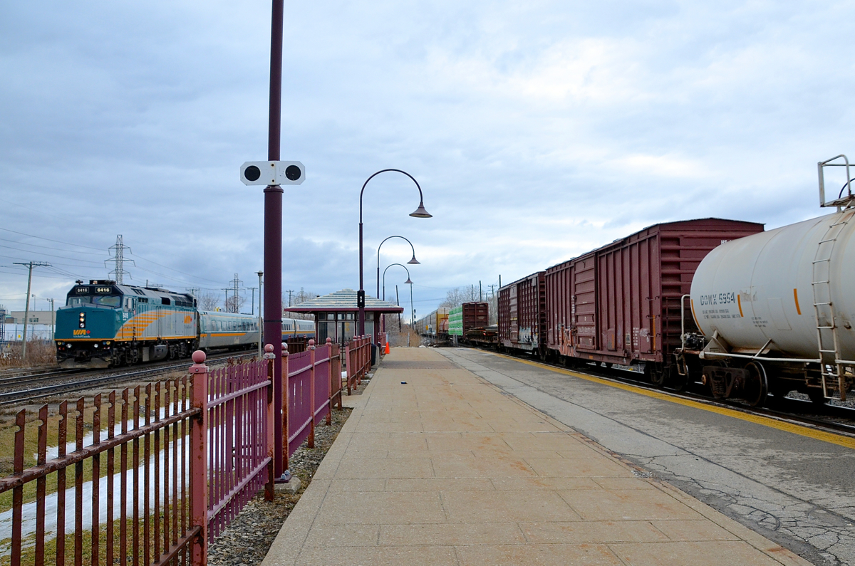 Eastbound on both CN and CP. Two eastbounds are through Dorval simultaneously, with VIA 50 at left on the Kingston sub seconds away from making its stop at VIA's Dorval station, while CP 118 at right passes through the AMT Dorval station.