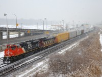 <b>Thick snow falling.</b> CN 401 has CN 8917 & CN 2407 for power and 104 cars as it approaches Turcot West in Montreal on a snowy afternoon.