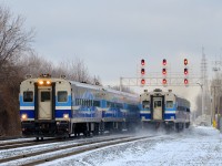 <b>Comet cars heading west and east.</b> At left AMT 87 for Candiac is heading west towards Montreal West with cab car AMT 707 leading. At right a deadhead move heads east towards downtown Montreal with AMT 708 at the rear. Both trains have consists of Comet cars built by Bombardier during the late 1980s.