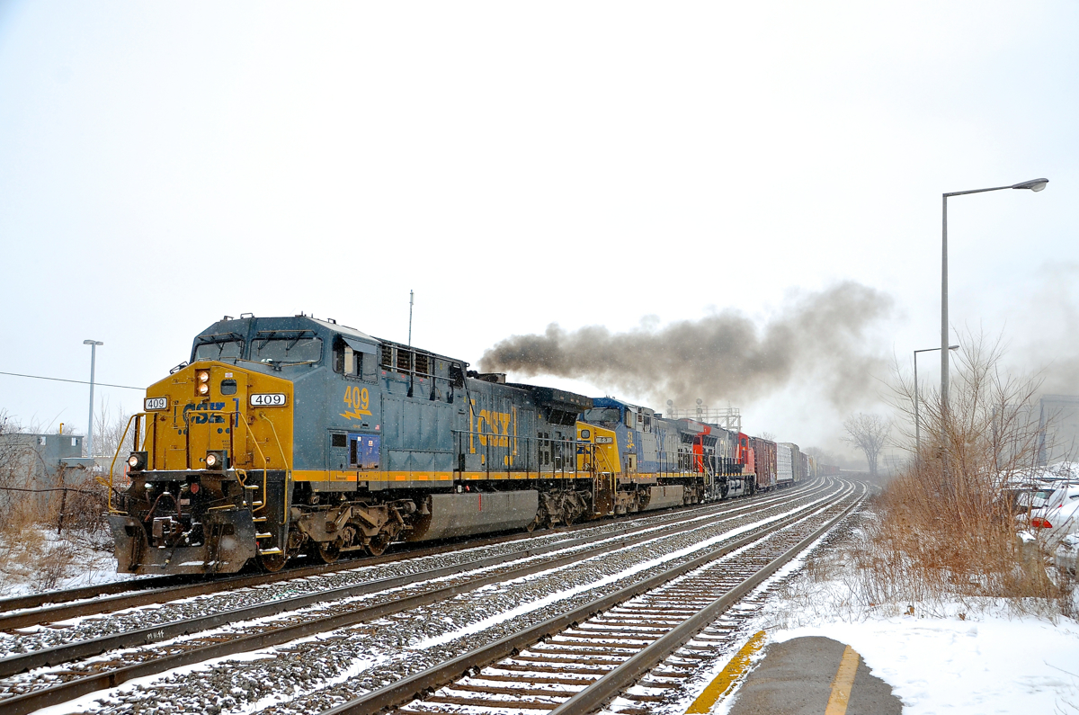 A repainted GE smoking it up. Recently repainted AC4400CW CSXT 409 smokes it up as CN 327 starts to accelerate after waiting for CN 368 to pass on the north track. Trailing are non-repainted AC4400CW CSXT 53 and ET44AC CN 3031.