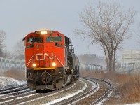 <b>AMT east, CN west.</b> CN 377 is heading west through Dorval with CN 8008 leading. At left AMT 24 heads east after stopping at the AMT Dorval station.