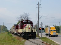 <b>Crossing over a sidewalk.</b> After picking up cars in Putnam and Ingersoll, GP9 OSRX 1620 and FP9A OSRX 6508 head to Woodstock.