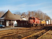 Rather frosty but sunny morning in late April as CP 6062 and UP 4058 are Toronto-bound with a stack train. The newly restored CP station is now a gift shop and art gallery and certainly has a lot of eye appeal. Great restoration job!! Southbound trains along this track now are a rarity; as directional running thru is area has trains northbound on this CP track while the CN track thru town is used for southbounds.