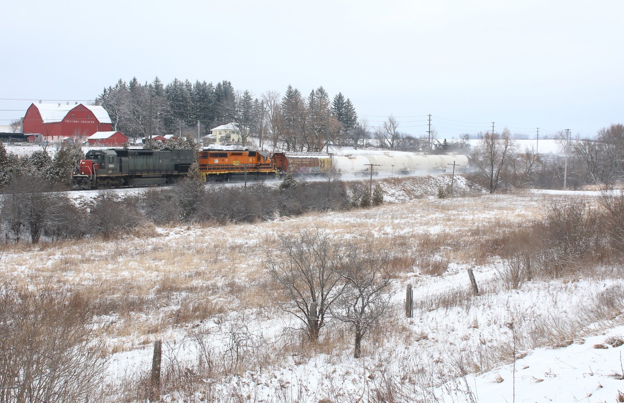 GEXR train 431 is seen kicking up fresh snow as it passes Venture Heights farm just east of Guelph.