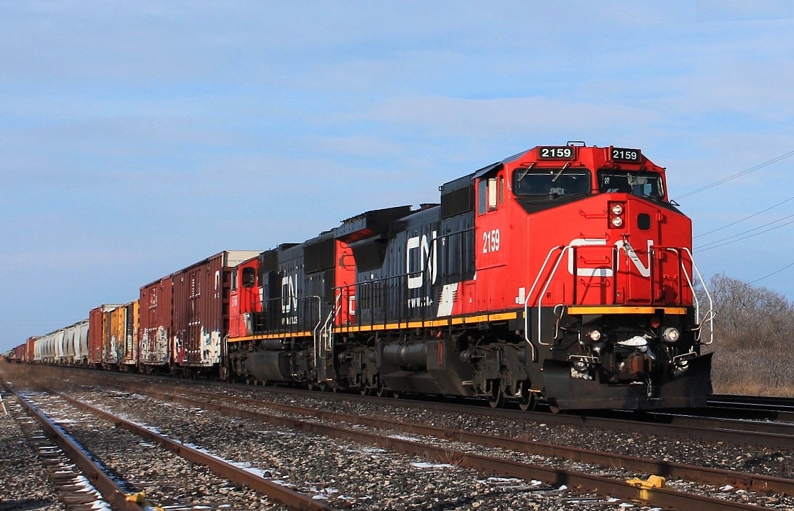 An eastbound consist rolls through the yard with a mixed freight.CN 2159 & 5766 in charge.