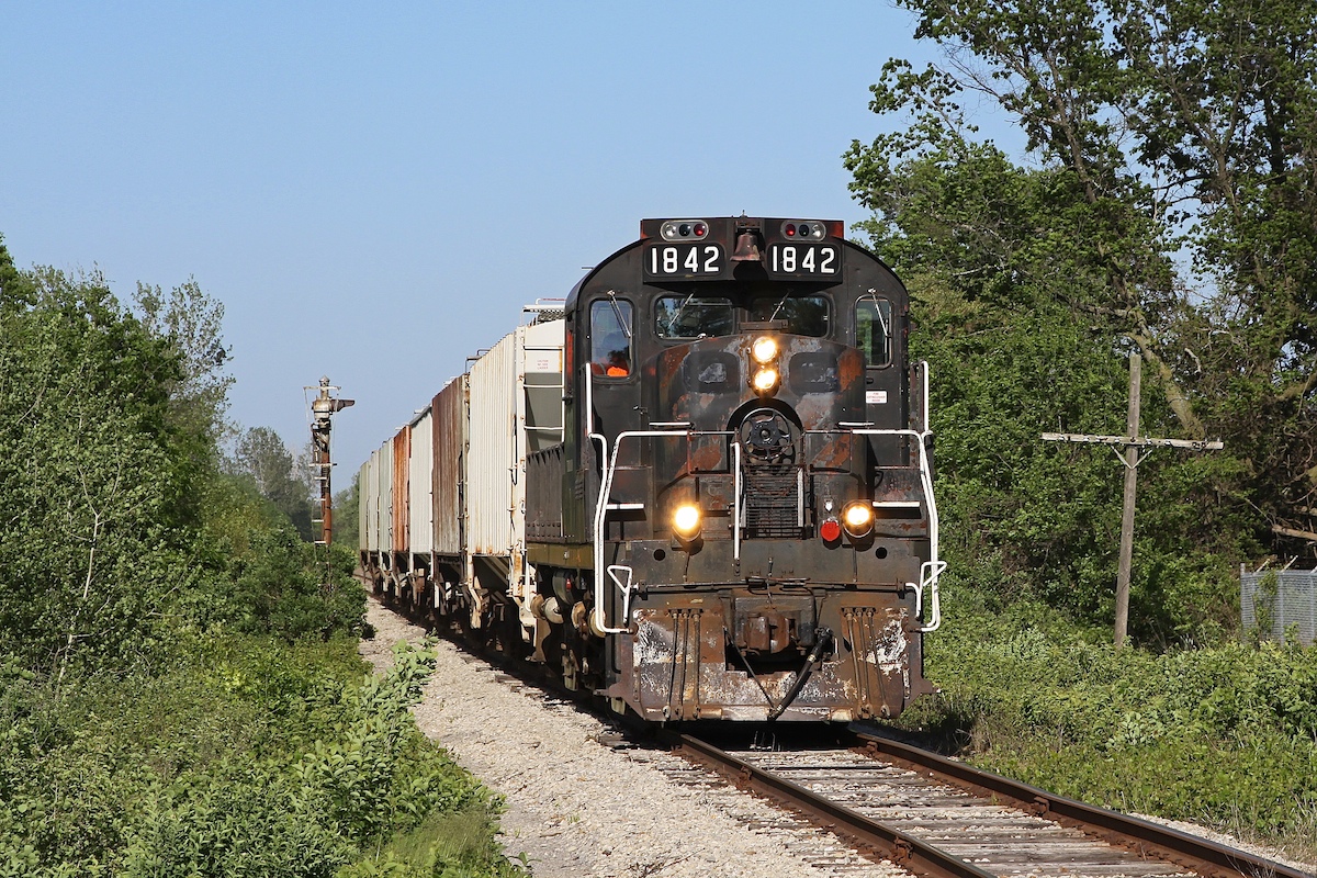 This was the best result I ever got from shooting the St Thomas & Eastern Railway.  It seemed, to me, that the trains would head west in the morning and east in the afternoon making all my attempts backlit.  Now on this fine summer day I had spent the morning and early afternoon following the OSR and later in the day decided to go over to Trillium's shops and take a photo of 1842, as it could often be found parked outside their office.  But it wasn't there and, on a whim, I decided to drive to Delhi so I could see where the end of the line was.  As I drove down Hwy 3 in Delhi, I looked down the track as I crossed over it and I saw the headlight of an engine east of me on the main.  It's hard to explain to most people the kind of excitement I felt at this moment, but I'd hazard a guess that everyone on this site can understand why I quickly slammed on the brakes (subsequently needing to wave an apology to the driver behind me) in order to try and have a longer look.  The next hour was spent waiting for the train to begin its journey back to Tillsonburg and then leapfrogging its slow trek home, photographing it at nearly every crossing between Delhi and Tillsonburg.  And not only is it the best shot I could get of the ST&E, it was also the last, as I never made it out again before the railway shut down in 2013.