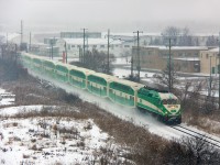 The last southbound GO train from Barrie has just left York University GO station and has reached the track speed of 75mph in no time thanks to a downhill grade. The former CFB Downsview base stands in the background, which is now owned by Bombardier for testing. A morning snow storm is just tapering off, however visibility is still relatively poor. Despite how easily GO tends to be affected by inclement weather, this train is making good time.