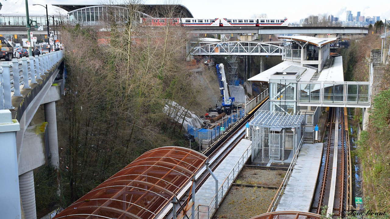 Commercial-Broadway Station on the Skytrain Millennium Line with bridge to the Commercial-Broadway Station on the Expo+Millennium Line.  The Commercial-Broadway Station was originally two separate stations: Broadway Stn and Commercial Drive Stn.  Broadway Stn completed in 1985 and the Commercial Drive Stn 2002.

The Commercial Stn portion in the photo sits in the Grandview Trench which also accommodates CNR and BNSF (the trench not the station).  Cars at top leaving the Broadway Stn for downtown.
