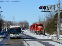 Photo two - the first in this series is <a href=http://www.railpictures.ca/?attachment_id=23278>T99 northbound at Preston photographed 20 minutes earlier</a><br><br>The Grand River Railway was built to convey passengers and freight. A Grand River Transit bus, which is the eventual successor of the passenger carrying <a href=http://www.railpictures.ca/?attachment_id=10298>Motorcars that plied the double track line</a> now waits for a southbound freight. The Waterloo sub is easily good for 100 freight cars a day, but soon may carry thousands of passengers a day. Not only does the Hagey job work three shifts per day, Wolverton to Hagey turns run 6 days a week in daytime, and sometimes at night to bring cars to this busy line - mostly for Toyota Cambridge assembly. This means two trains are on the line fairly often - under OCS control f.y.i.<br><br>Passengers you say? Waterloo Region is busy building the ION Streetcar route duplicating the efforts of the GRR (and the former <a href=http://www.trainweb.org/elso/kw_st_ry.htm>Kitchener-Waterloo Railways Streetcar system</a>) and if phase two happens as planned, this picture will change significantly in the next 10 years, ION is planned to use the CPR route to get down to Galt. Hence, in due time, the Grand River Railway may  again become a busy freight and passenger carrying railway. What is certain though is ION will be on its own right of way, we'll just have to stay tuned to see how they plan to make this happen, assuming phase two even occurs.