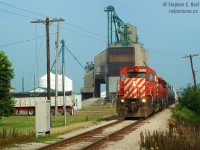 <b>A few things have changed</b> since this photo was taken along the CSX Sarnia Subdivision. <b>Abandoned:</b> Trains no longer roll by this point, for now, and possibly for-ever - trains only run as far as mile 53, and we're sitting at 45.6 at Clancy (near Whitebread Line). Also, don't be fooled, it's a CSX Train on CSX track using run-through power from CP with 49 cars - CP's main job was to bridge the traffic to Detroit from Chatham since the 'great retreat' nearly 20 years ago which ended CSX Detroit-Buffalo run-through service through Ontario. CP 5679 trailing is no longer on the CPR Roster, the leader is still here, for now, Tied Up Unserviceable (TUSV) at St. Luc. <b>The Codeline</b> is still in use as you can see, it's used to power the crossing protection. The codeline was all cut up on one of my last visits so I believe they would have converted power to local hydro utility connections.<br>What else has changed? One thing you young guys won't think of... <br><br><b>NO SMOG</b> one thing I notice in my photos from this era, SMOG all the time, everywhere, especially in the Sarnia to Chatham area in the summer months. When was the last smog day??? They were constant at this point in time.. and tinged blue skies a hint of brown, even looking  almost cloudy!<br><br>I spoke to some of the employees at the elevator on this day and they were pretty blunt 'good riddance' to CSX as the rumour of abandonment whirled around, they had no need for the railway. While the property has changed owners in the last 10 years, sadly for them, even if they wanted rail service they are on the CSX side of the end of track... and I don't think they will ever get rail service again as there is significant politics involved to STOP any incursion north into Sarnia by any competitors of CSX and CN - CP came really close, three times in fact, to having a semblance of service in Sarnia and this period in time was one of them. The first was rumours CP was offered the C&O Canadian Division to Sarnia - even going as far as running a CP business train to Sarnia in 1977. The second was the time you see here - CP clearly had their foot in the door.. and CP ran trains on the PM (CSX) in Michigan at the time.  The third time was in 2007 when they basically purchased Chatham-Kent's interest in the Wallaceburg to Chatham roadbed (not land) in anticipation of Shell's failed new refinery - and this was a secret until 2014 when Chatham-Kent were told by CP, pay up or we run a rail train - they want their rails and forced a decision to buy it back. The region actually bought their interest back, thankfully, since there is talk of a large fertilizer company locating a plant somewhere in the vicinity and without rail service... there won't be a plant in Chatham-Kent.<br><br>Ultimately, there is hope for this line - we just have to let the hourglass of time tick on, and continue the <b>change</b> and see what happens. Great advice from others: <b>Keep taking photos</b>, because change will continue and only in time will you really start to notice the <b>changes</b> :) <br><br><b>Bonus audio clip:</b> Another change: no more  RTC's (in Canadian parlance!), no more OCS - now rule 105 territory, and closing of the 'smallest Dispatcher office on CSX' which occurred in October 2013. Here's an audio clip of the RTC and Crew, recorded at 0810 (Photo time 0923)  <a href=http://steve.hostovsky.com/clearance_south_sarnia_mile_25.mp3> Click here for the 2 meg .mp3 file </a>