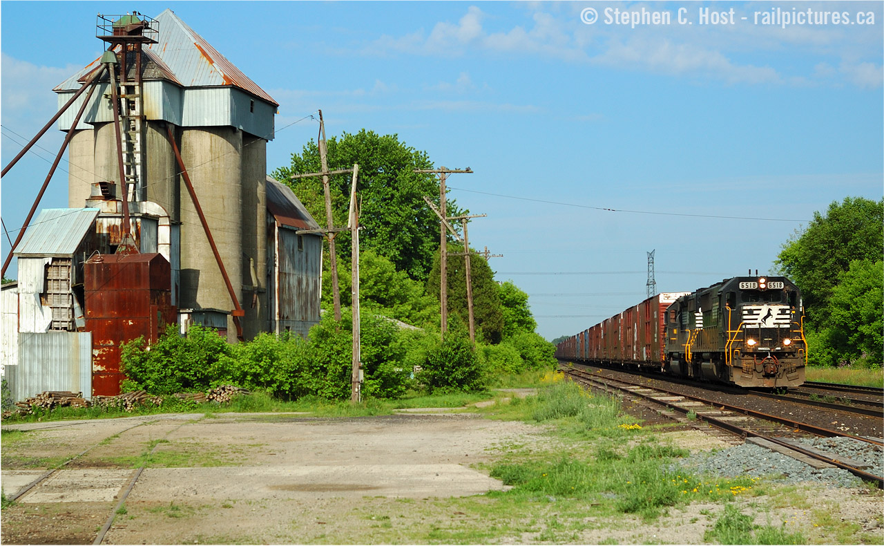 While not old enough for the Time Machine, I would challenge a viewer to dig out an even older image if you feel like it of course :).  In response to Joe Bishops's Copetown shot posted today, I happened to be looking at this photo the other day and felt it was a timely dig-out from my 'archive'. Nearly 10 years ago we see NS 328 with SD60 6518 and High-hood SD40-2 3308 with 35 cars rolling by the Copetown feed mill, and you can easily see some of the changes over the last 10 years. If anyone has something older than this.. no complaints if you wanted to dig it out :)

Things were busy that morning. NS 328 went by at 0900. At 0904,  a CN westbound with 2444/CSXT 8115 went by on the north track. At 0913 NS 327 passed by with  NS 9146, NS 9836 and 15 cars, also on the north track. Three freights in 15 minutes, not bad. I followed 327 to Lynden (in futility, NS 327 was permitted to run at 70 MPH - 10 MPH faster than typical freight speed!). After missing 327 at lynden at 0922,  an eastbound went by at 0941 with BNSF 538 leading WC 6003, CN 5605, CN 9441 and a general freight.I spent a lot of time watching and photographing in 2006, much more than I do these days. The sheer volume of freight difference in the last 10 years is staggering. I count 19 trains one morning in 2006.. today i'd be happy with half that number.