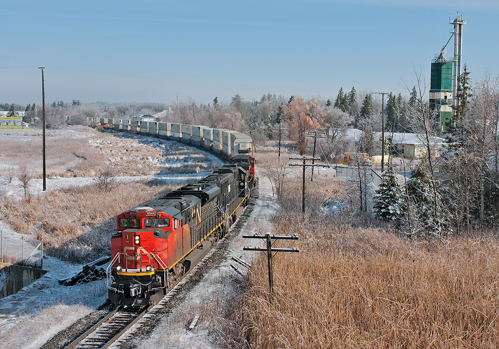 The sun shines bright on this cold spring morning, so I drove up to shoot a few trains on the Bala before the ice melts from the surrounding landscape. Running at full throttle, CN 114's three big units have 11,011 ft of train well in tow for BIT.