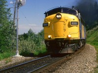 The westbound "Canadian" is smoking it up as it accelerates at the east end of Brickburn siding. The remote control motor for the switch is seen in the forground.