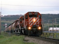 In the mid 80's there was a "Day in the Life of...." craze (for lack of a better word). This was the first railroad-related event - preceding CTC Board's first Day in the West (In a few years it would become all of Nort America) by one day. Someone in St Catherines of Welland was organizing the event and asked photographers to make submissions. I sent is several shots that I had taken that day, but nothing ever became of the project. Nor were my slides ever returned to me. I am still rather ticked.
So, this is a shot that I did not submit, of a westbound grain train approaching the high point of Brickburn. The small bridge that the train is on is for the Trans Canada Highway.