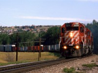  In the mid 80's there was a "Day in the Life of...." craze (for lack of a better word). This was the first railroad-related event - preceding CTC Board's first Day in the West (In a few years it would become all of Nort America) by one day. Someone in St Catherines of Welland was organizing the event and asked photographers to make submissions. I sent is several shots that I had taken that day, but nothing ever became of the project. Nor were my slides ever returned to me. I am still rather ticked. 
This eastbound high priority train is crossing the Bow River out of frame to the left and is about to hit the west switch of Brickburn in west Calgary.
