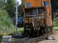 The tail end of an empty grain train passes the east switch and signal of Brickburn.