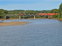 CN 406 with a long string of Potash Corp. hoppers up front glides across the Hammond River heading for St. John.
