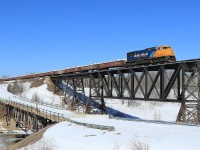 A sinlge SD70I locomotive (the typical power for this train) leads 53 cars over the bridge at Monteith.