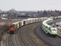 CN 372 takes the service track for Oshawa Yard while a GO commuter train passes on the other side of the line.