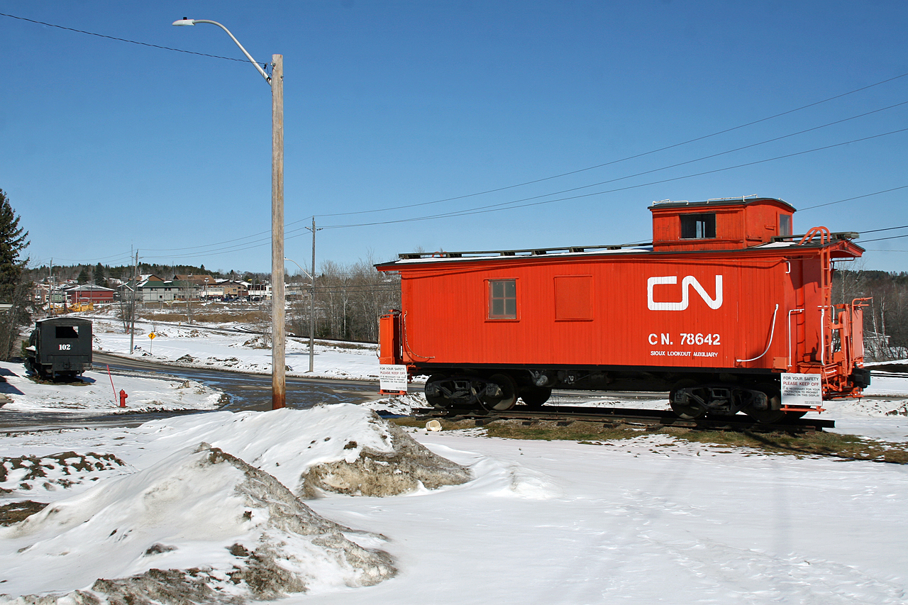 Wooden caboose CN 78642, the Sioux Lookout Auxiliary sits on display just south of yard and town of Sioux Lookout Ontario.  CN 78642 rebuilt in Moncton in 1948, was originally built by ACF in 1912 as GTW 83287.  Just across the road is an MLW 0-4-0 steam engine, Canada Creosoting 102 which was built in 1923 for the Quebec Development Company.  If you look closely at this photo, you can see the tail end of the wye  behind the caboose, along with the current CN office/bunkhouse in the background (building with the green roof).  Like many places in Northern Ontario, Sioux Lookout is a shadow of its former self railway wise with few signs of the rich railroading history still visible.  The town used to feature an 18 stall roundhouse, large yard and just east of Sioux Lookout at Superior Junction, the Graham Sub diverged southwards to Thunder Bay.  All that remains today is a small yard and empty fields where the servicing facilities used to be located.  The original station at Sioux Lookout has been renovated to serve passengers from VIA's Canadian.  CN crews still trade off here, with Winnipeg crews handling trains on the Redditt Sub and Sioux Lookout crews working the Allanwater sub to Armstrong.  As for the Graham Sub, it was abandoned and Superior Junction was renamed Superior.  You can still see where the word Junction was painted over and the former right of way climbing away from the mainline and heading south into the forest towards Thunder Bay.