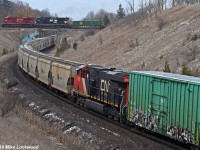 Every so often one will hear CN blowing for the old Beare Landfill grade crossing and CP for either Ressor Road to the west or Beare Road to the east, only to have the over/under shot marred by less than ideal timing. Case and point, a 206 car CN 305 makes its presence known to the south, moments later followed by CP to the west. CN is climbing a grade, whereas CP is not. But CP's trains are longer and if eastbound, they're only just beginning to accelerate out of yard limits as the power draws near to the bridge and not exactly making time on the approach. With CN 3010, 2662, and DP 2932 providing the impetus, and 125 of their 206 cars being potash empties, CN 305 easily gets to the over/under before CP. Opportunity lost. 
<br><br>
So what are the odds of the over/under between the CN DP and the CP's headend? Apparently pretty good. Even better, CP 142's power includes a little bonus in the form of a former Conrail C40-8W, NS 8427, trailing CP 8879. Nice. 1206hrs.