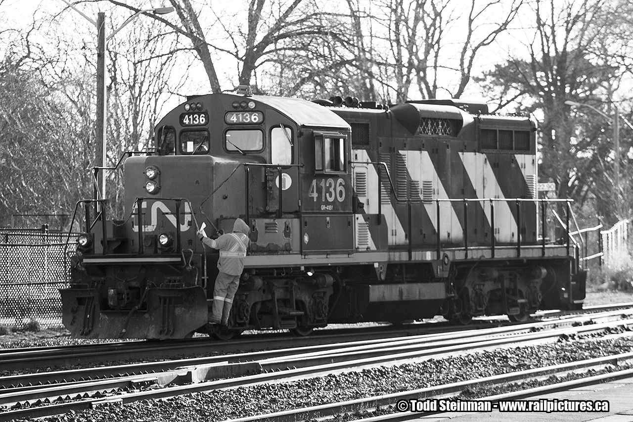 It's spring, and the crew in charge of CN 4136 have already gotten a jump on the day performing switching duties in the Brantford yard. Here, the conductor rides the engine to throw his next switch. Of note...4136 had served previously as the yard engine in Huntsville. You can see that photo here: 
 http://www.railpictures.ca/?attachment_id=21044