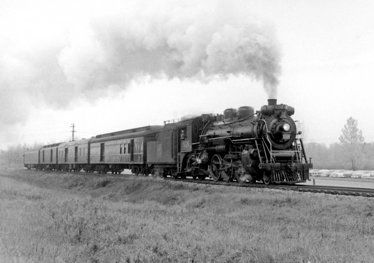 Canadian National Railway train 173, behind J-4-e 5126 and with a consist of four cars in tow, has just left Guelph and is shown running beside Edinburgh Road in 1958.

CNR 5126, a 4-6-2 "Pacific" built by MLW in 1920 as part of CN's J-4-e class, was scrapped two years later in February 1960.