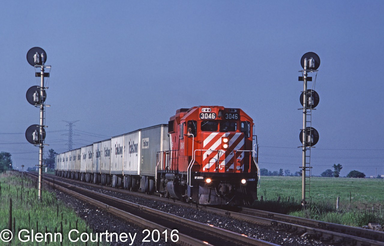 CP Rail GP38-2 3046 splits the signals at Hornby with the Roadrailer train, #529, running on the south track to run around the GO trains using the north track.
