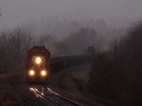 CP 6042 E is in charge of a welded rail train with 27 strings for the Montreal area. A dark, wet and gloomy scene seemed fitting for this an SD40-2 running on borrowed time.