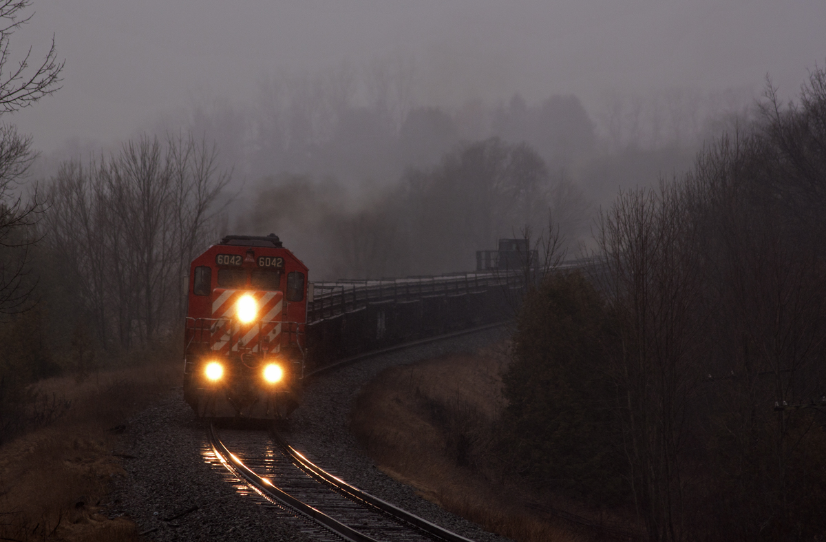 CP 6042 E is in charge of a welded rail train with 27 strings for the Montreal area. A dark, wet and gloomy scene seemed fitting for this an SD40-2 running on borrowed time.