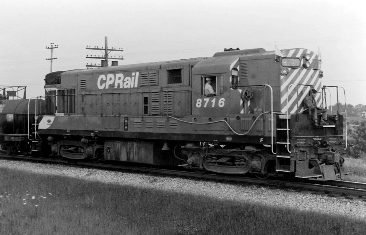 CP sent a pair of CLC H16-44's (8715 and 8716) east in 1972 to work with the Speno rail grinding train (the two were specially equipped with pace-setter equipment to maintain a constant speed while the train was grinding). Here's 8716 with the rail grinding train on the Galt Sub at Thamesford. Note the hose man riding the front of loco, whose job it was to eliminate any fires, burning embers, etc after grinding. A water hose runs from him along the flanks of the unit, to the tank car behind.