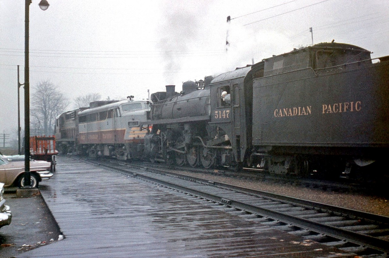 Another view at Galt showing transition-era railroading: a pair of newer diesels (CP RS18 8744 and a 4020-series FA1) doublehead with P1-class 2-8-2 5147 on a westbound freight, passing the parked cars and baggage cart along the platform in front Galt Station, on a rainy October day in 1959. There were no MU controls between diesel and steam (at least back then), so both had to be run with their own crews operating in unison.

The same train arriving at the station: http://www.railpictures.ca/?attachment_id=14286
