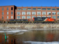 <b>Passing the old Stelco mill.</b> GP9 CN 7272 & slug CN 274 are heading light along the East Side Canal Bank Spur on their way to Robin Hood mill to pick up 7 empties. They are passing what was part of the Stelco steel mill, now it is part of a condo complex. Once a common sight along both sides of the Lachine Canal, trains are now very rare, with Robin Hood mill being the only rail-served client along the length of the entire canal.