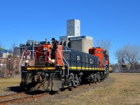 <b>Switching at Robin Hood slug first.</b> Slug CN 274 and GP9 CN 7272 are at Robin Hood mill to pick up 7 empties at the end of East Side Canal Bank Spur. Once a common sight along both sides of the Lachine Canal, trains are now very rare, with Robin Hood mill being the only rail-served client along the length of the entire canal. Barely visible at left behind the mill is the skyline of downtown Montreal.