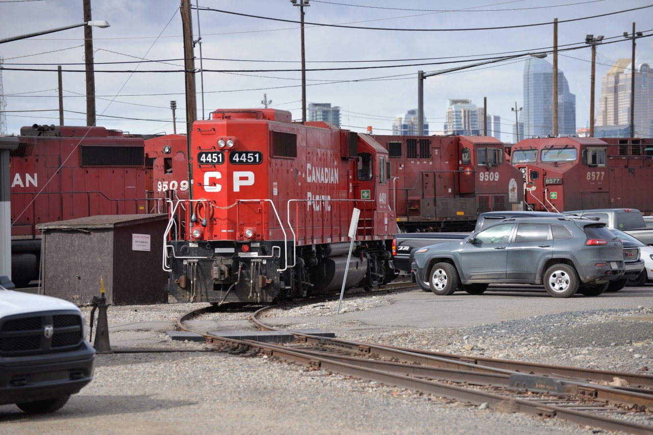 CP4451 (EMD GP-38-2) idles into the siding to pass thru locked gates to the pick up some tank cars, in alyth Yard , Calgary CP 9509 and 8577 (GE AC44CW) awaiting orders in the back ground.