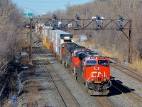 <b>Leaving Taschereau Yard.</b> CN 120 is starting to exit Taschereau Yard as it passes under a signal bridge on CN's Montreal sub. Power is CN 2855, CN 2194, CN 5787 & CN 2862 mid-train, the train has 540 axles total.