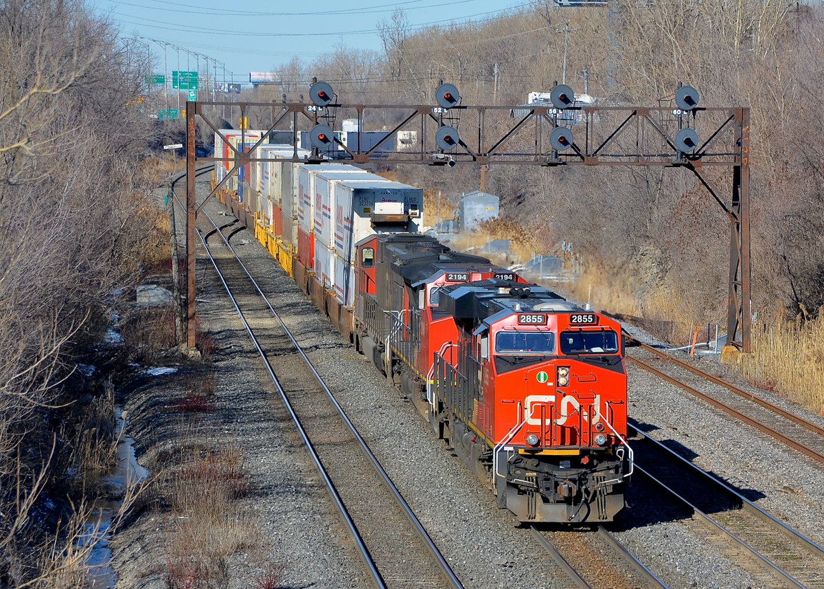 Leaving Taschereau Yard. CN 120 is starting to exit Taschereau Yard as it passes under a signal bridge on CN's Montreal sub. Power is CN 2855, CN 2194, CN 5787 & CN 2862 mid-train, the train has 540 axles total.