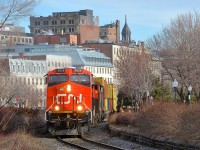 <b>Crawling through old Montreal.</b> All trains on CN's Wharf spur are limited to 10 mph, and even one of CN's hottest intermodal trains (Montreal-Chicago intermodal train CN 149) is not exempt from this restriction as it crawls through old Montreal with fairly new ET44AC CN 3026 leading two more GE products (CN 2861 & BCOL 4621).