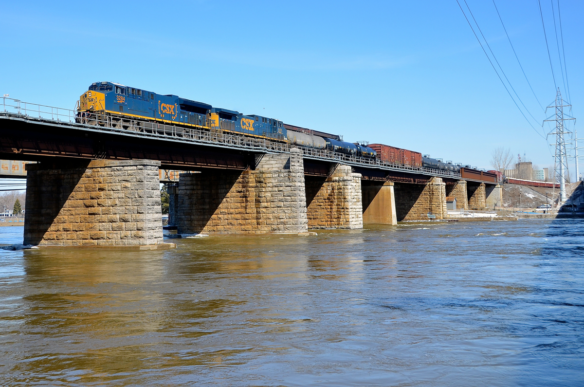 CN 327 over the river. CN 327 is crossing over the Ottawa River with new ET44AH CSXT 3284 leading and CSXT 5101 trailing.