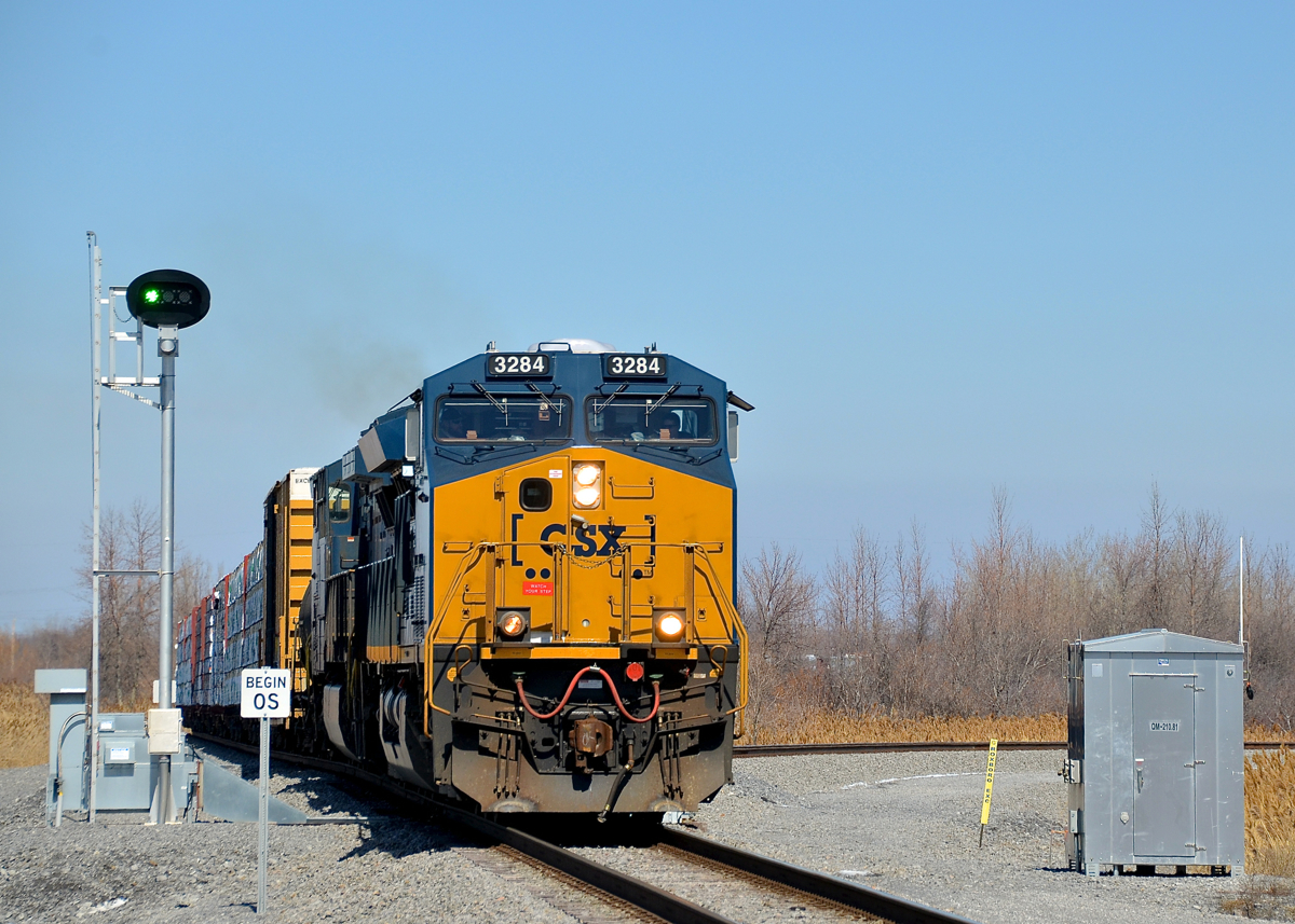 Not a signal, but a switch point indicator. CN 327 with fairly new unit CSXT 3284 leading and CSXT 5101 trailing is passing a switch point indicator which indicates over the radio whether the switch is lined for the main or the diverging route. The track at right is the south switch to CSXT's new intermodal terminal in Valleyfield.