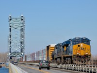 <b>Sharing the bridge with road traffic.</b> The Saint-Louis-de-Gonzague bridge over the Beauharnois canal has 2 lanes for road traffic, as well as a single track for CSXT's Montreal sub. Here CN 327 is crossing over the bridge with new unit CSXT 3284 leading. Trailing is CSXT 5101.